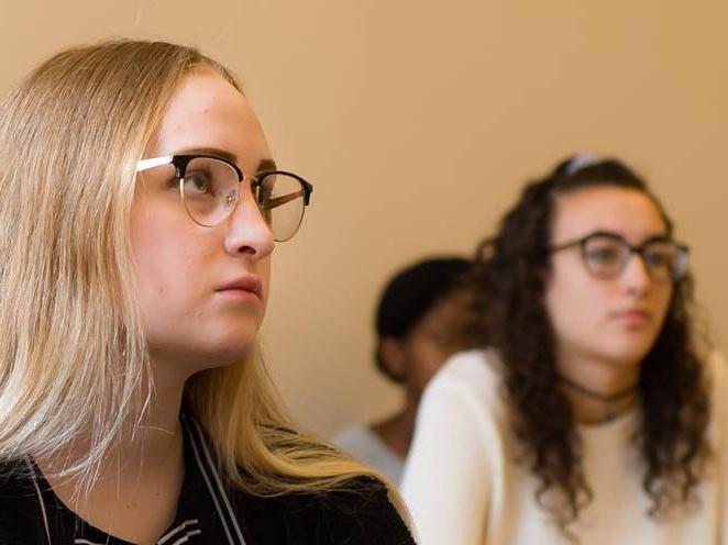 Two students seated focusing