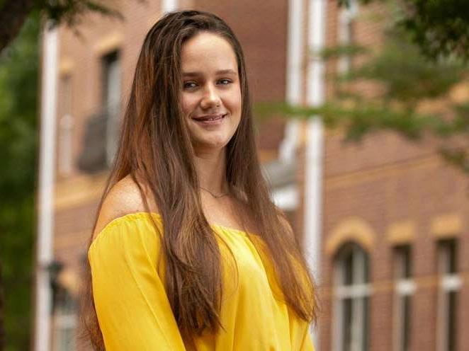 Young women standing infront of a building smiling for a picture