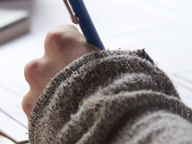 Student is writing with a pen